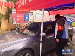 南昌青山湖区京东镇京荣社区工作人员给进出车辆上的人员测量体温